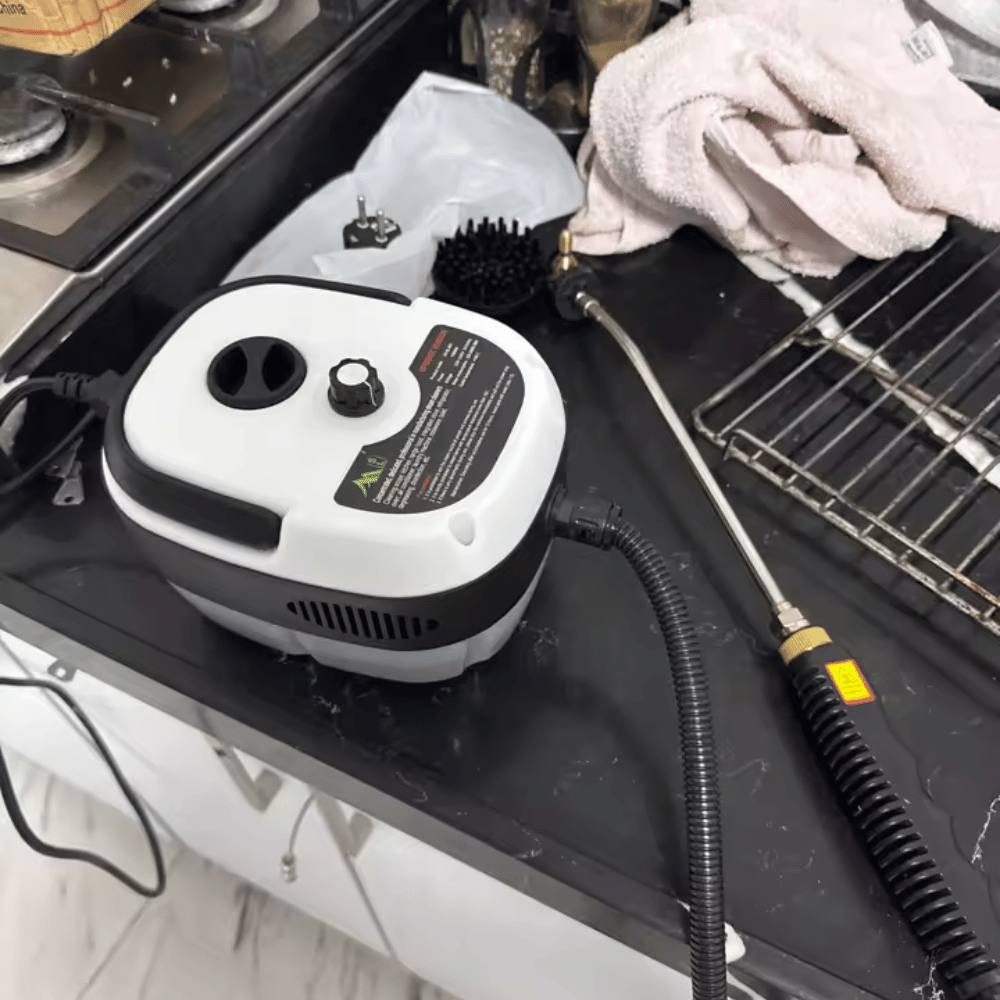 Steam cleaner on a kitchen counter with gloves and cleaning tools nearby