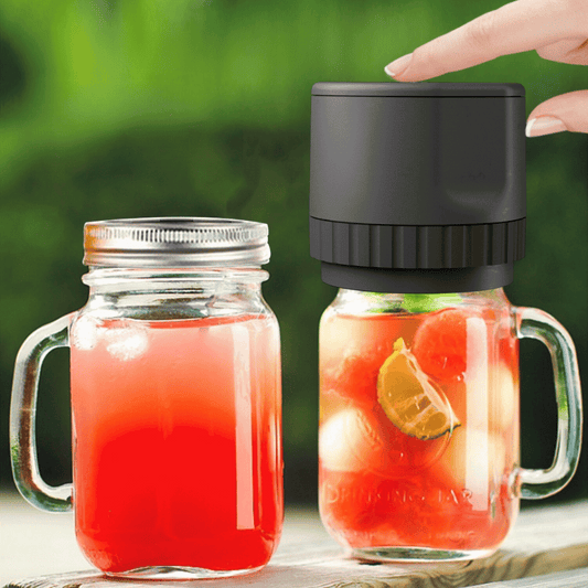 Two glass jars with red liquid and lemon slices, one with a black lid being held by a hand.