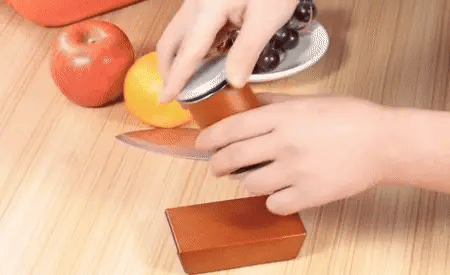 Close-up of Magnetic Rolling Knife Sharpener being rotated by hand, showing ergonomic roller and diamond sharpening stone